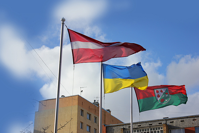 Pie pašvaldības ēkas plīvo Latvijas (no kreisās), Ukrainas, Olaines novada karogi