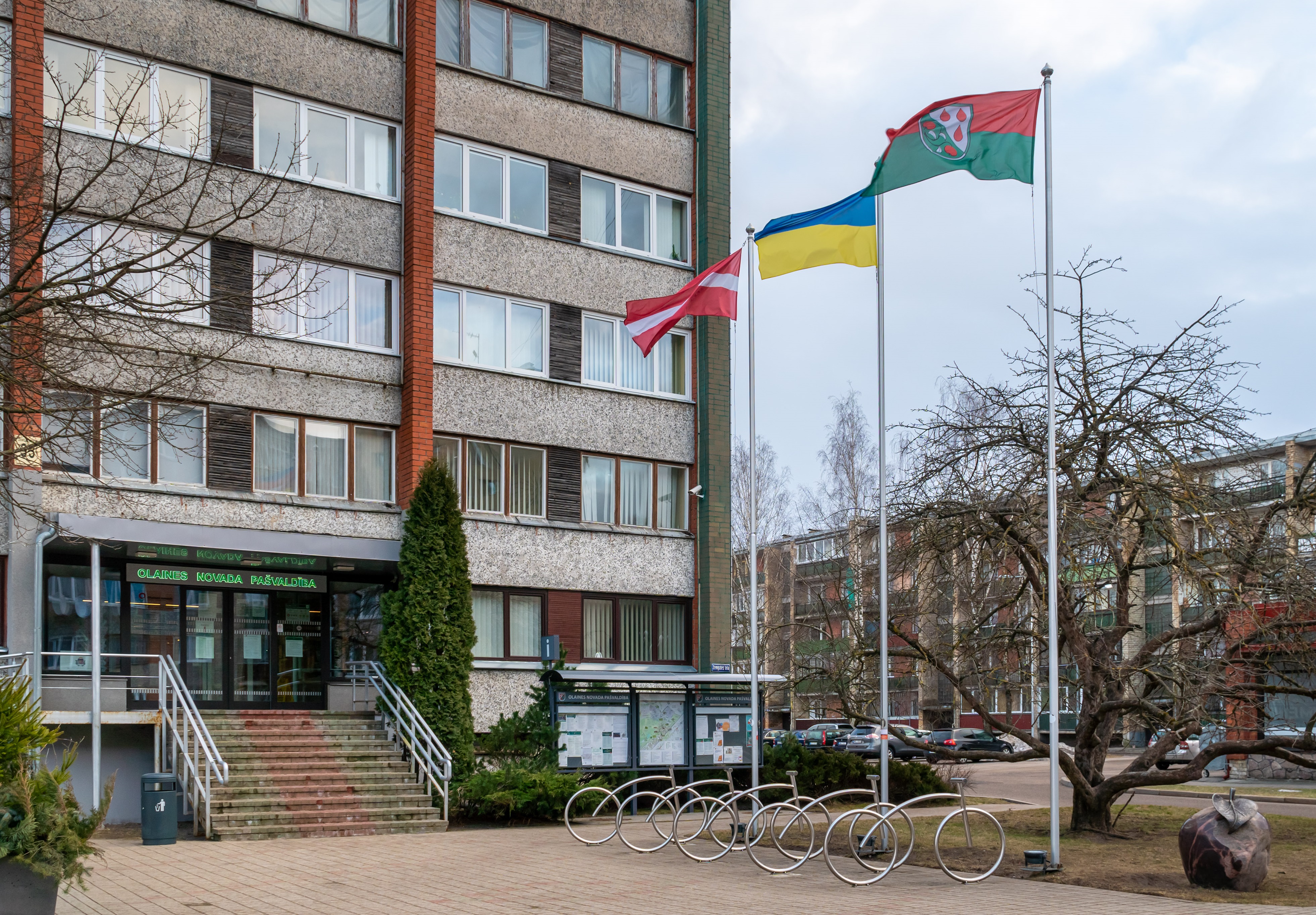 Karogu mastos pie pašvaldības ēkas  ir Latvijas, Ukrainas un Olaines novada karogi.