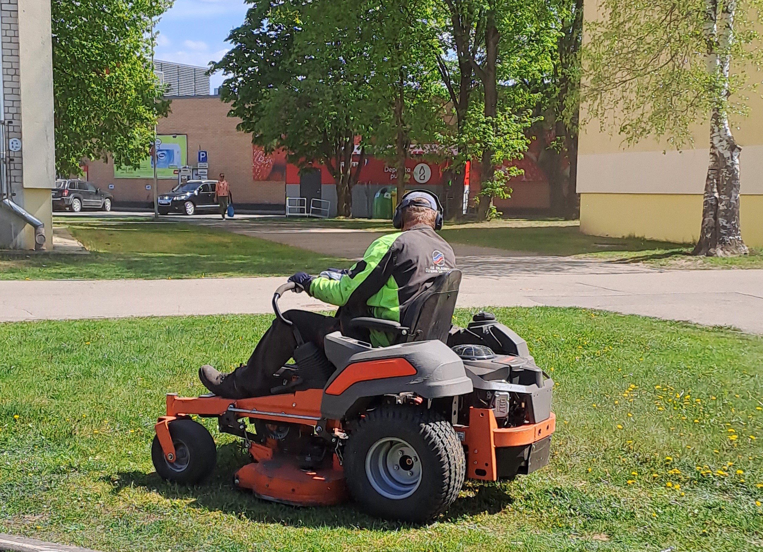 AS Olaines ūdens un siltums darbinieks pļauj zāli
